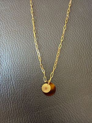 a necklace with a gold disc on a gold chain