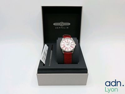 an image of a red and white watch in a black box