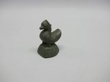 un gros plan sur une petite statue représentant un canard posé sur un rocher