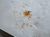 a dirty white refrigerator in the corner of a room