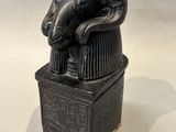 statue of a ram head on top of a box with an egyptian writing on it