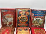 four books are lined up in a row on a white surface