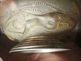 a gold vase with a horse on it in someone ' s hand
