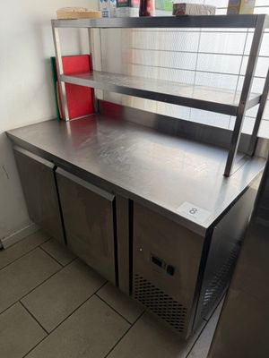 plan de travail en acier inoxydable dans une cuisine professionnelle équipée de poubelles rouges