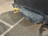 a black truck parked in a parking lot next to a yellow fire hydrant