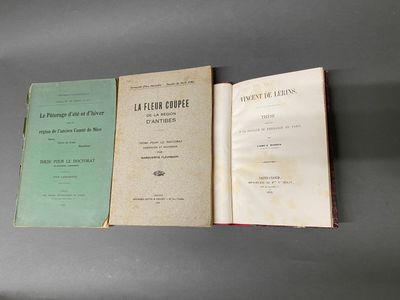 Trois livres sont posés sur une table ; l'un est ouvert et l'autre est fermé.