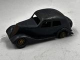 une petite voiture noire posée sur une surface blanche
