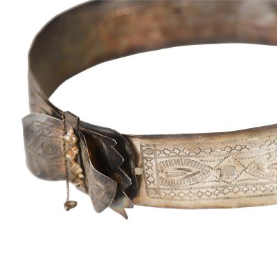 a close up of a metal bracelet with a flower on it