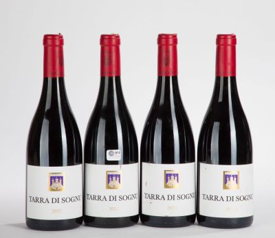 three bottles of red wine are lined up on a white surface