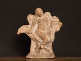 statue of a woman holding a bird on a wooden table