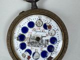 a pocket watch that has a picture of a train on it