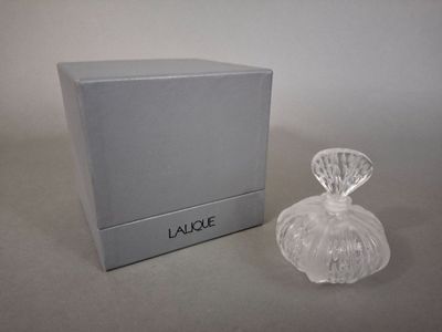 l'image d'un flacon de parfum à côté d'une boîte