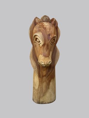 a wooden sculpture of a lion head on a gray background