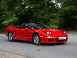 a red sports car driving down the road in front of a red car