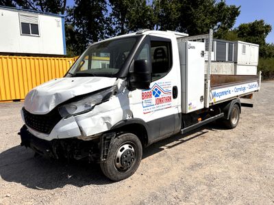un camion blanc endommagé, immobilisé dans la poussière