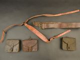 several items are laid out on a table, including a belt, a wallet, and a knife