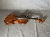 un vieux violon posé sur une surface recouverte d'un tissu