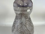 a gray vase with a black lid sitting on a white surface
