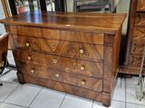 une commode avec un miroir et une chaise dans une pièce