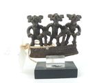 figurine représentant trois éléphants dans un bateau, posée sur un socle en bois
