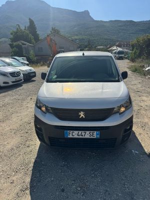 a silver car parked in a parking lot with mountains in the background