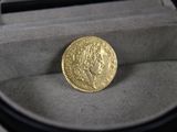une pièce d'or posée dans une boîte sur une table