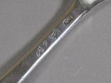 a silver spoon with a spoon handle on a table