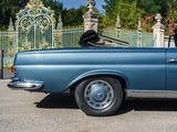 a blue car that is parked in front of a gate