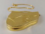 an image of a gold shoe shaped necklace on a white surface