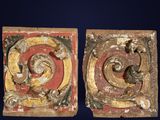 two pieces of carved wood with a red and yellow design on them