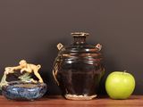 two vases and an apple on a wooden table