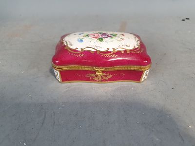 une petite boîte rouge ornée d'un motif floral