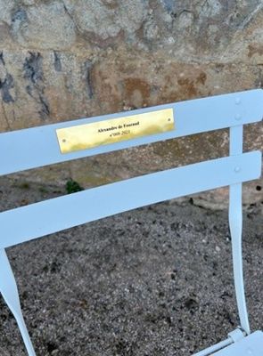 un banc blanc sur lequel est apposée une plaque