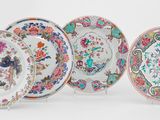 quatre assiettes chinoises ornées de motifs floraux, posées sur une surface blanche