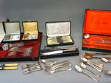 many different types of silverware on display on a table