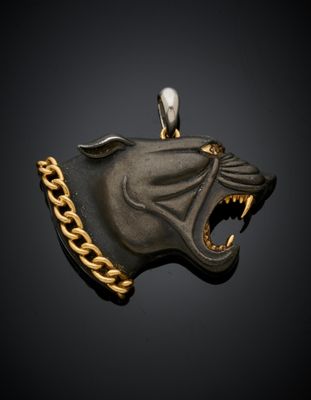 une image représentant un pendentif noir et doré en forme de tête de chien