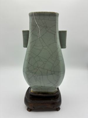 un vase vert posé sur un socle en bois