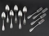 a group of silver spoons and forks on a black surface