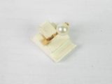 un petit objet blanc orné d'une perle