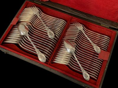des couverts dans un coffret en bois avec une doublure rouge sur fond noir