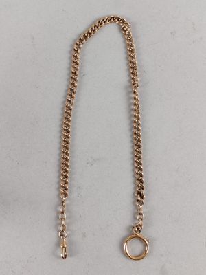 a close up of a gold chain with a ring on it