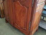 a large wooden armoire in the middle of a room