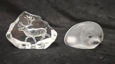 une paire de figurines d'animaux en verre transparent sur fond noir