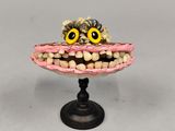 un gâteau surélevé, orné d'un visage composé de brosses à dents