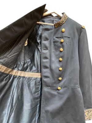 une image représentant un uniforme bleu à boutons dorés et une veste noire