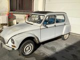une petite voiture blanche garée devant un garage