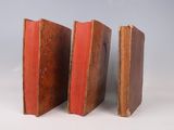 two old books sitting next to each other on a white surface