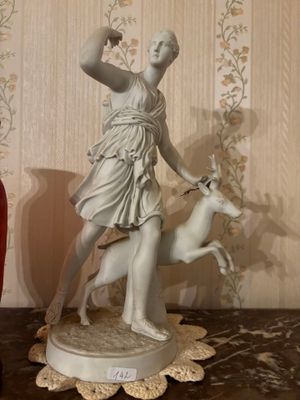 a statue of a woman and a dog on a table