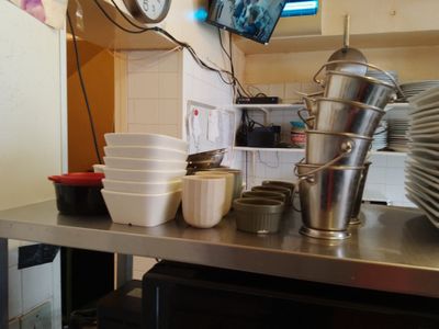 de nombreux bols et tasses sur le plan de travail de la cuisine
