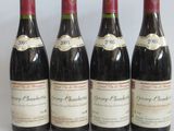 four bottles of wine are lined up on a white surface